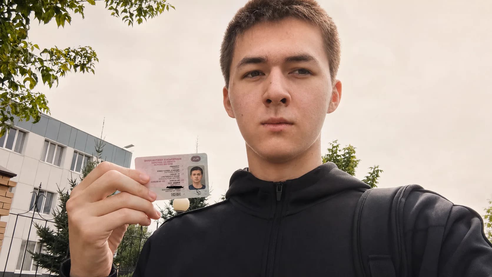 Ученик с водительским удостоверением после успешной сдачи экзамена